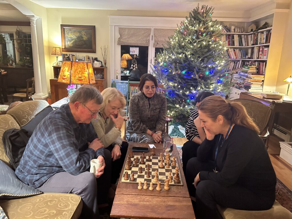 group in living room playing chess