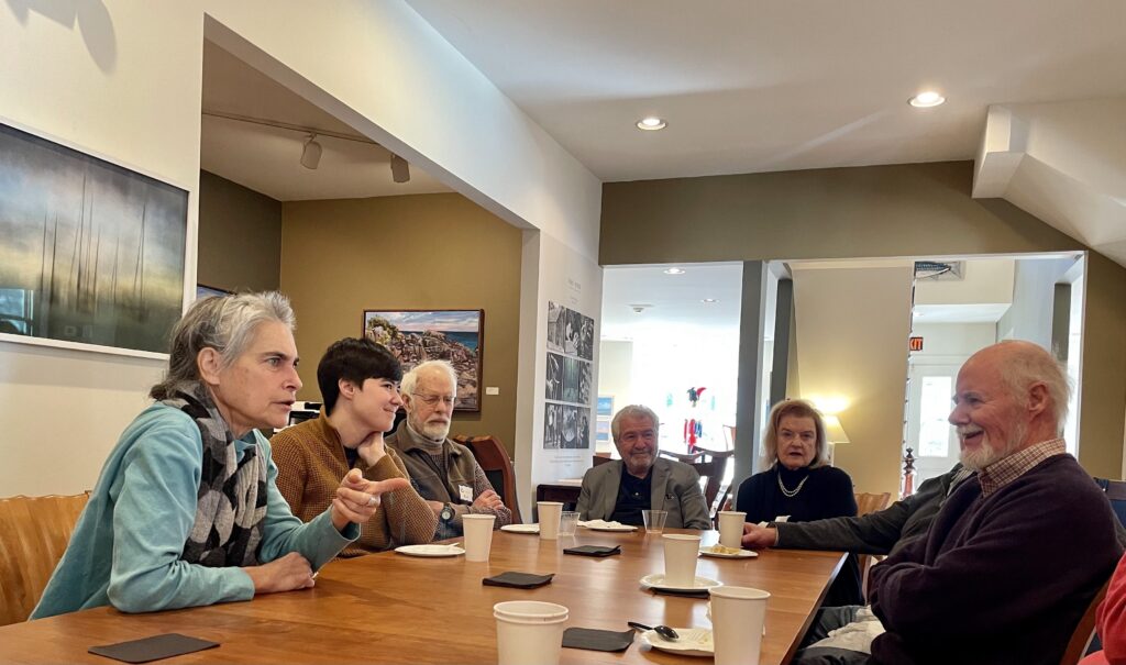 group of people talking around a table with coffee cups