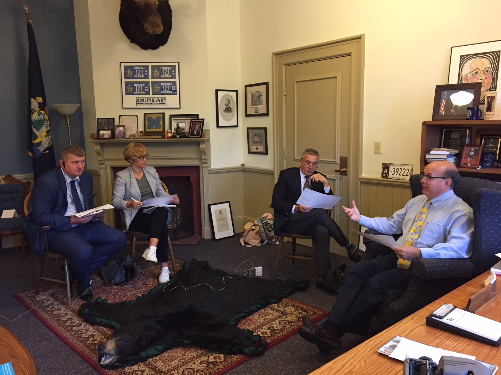 3 men and 1 woman seated in an office