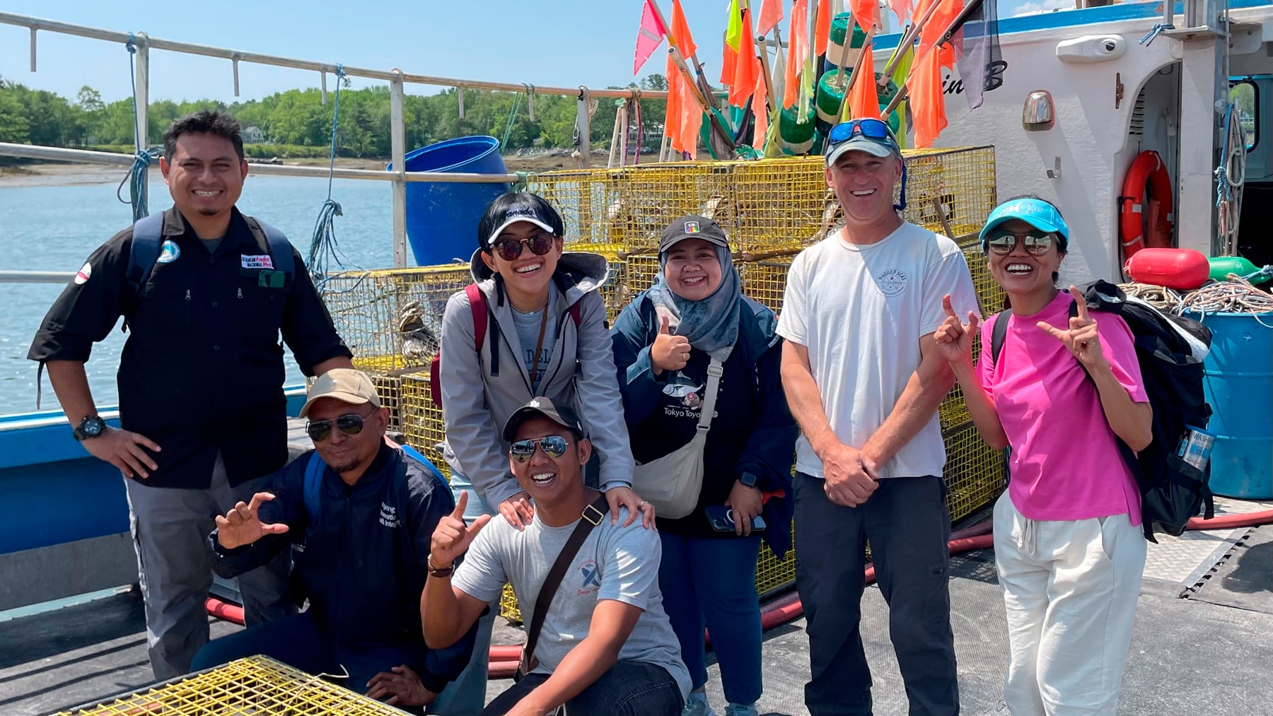 group photo by lobster traps and boat