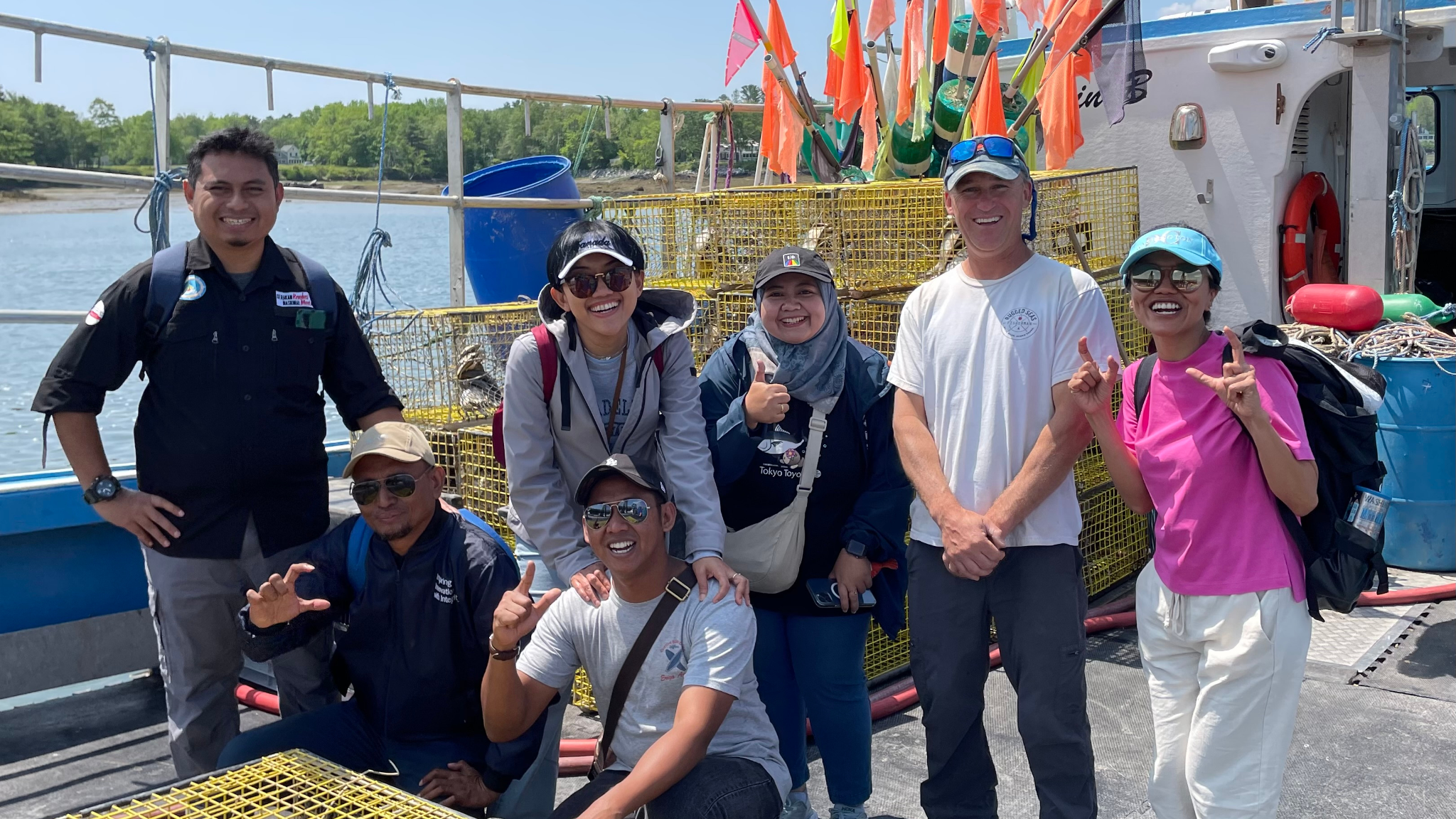 group photo by lobster traps and boat